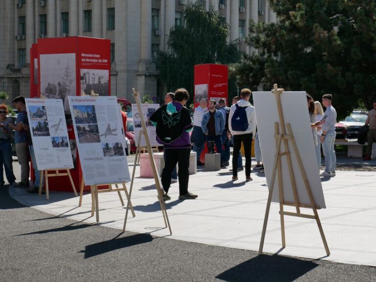 Oameni și panouri de expoziție în Piața Revoluției din București